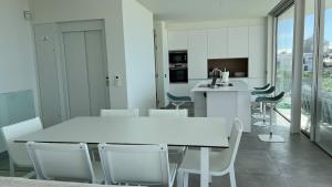 a kitchen and dining room with a white table and chairs at Luxurious villa with ocean views in Callao Salvaje