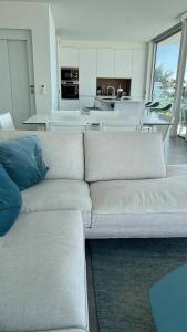 a living room with a white couch and a kitchen at Luxurious villa with ocean views in Callao Salvaje