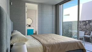 a bedroom with a bed and a large window at Luxurious villa with ocean views in Callao Salvaje +29 photos