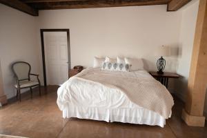 a bedroom with a large white bed with a chair at New Field Farm at Timber Ridge in Lexington