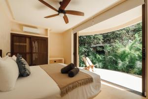 a bedroom with a bed and a large window at Kan Tulum Hotel in Tulum +110 photos