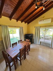a dining room with a wooden table and chairs at Náutico Apart Hotel in Chascomús
