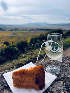 a glass of white wine and a piece of bread at Suite Richovilare - Sauna & Hammam in Riquewihr