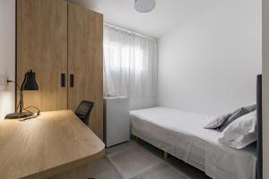 a bedroom with a bed and a wooden desk at Coliving San Esteban in La Ñora