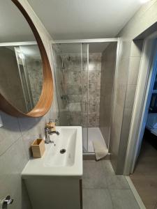 a bathroom with a sink and a shower with a mirror at Apartmán Klára in Terchová