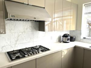 a kitchen with a stove top oven in a kitchen at Private 2BR, 1BA with shared Kitchen in a House, Free Parking, 15 Min YVR in Richmond +6 photos