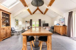 a dining room with a wooden table and chairs at De Gemoedelijkheid in Nuenen