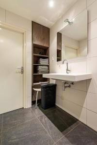 a white kitchen with a sink and a door at De Gemoedelijkheid in Nuenen +62 photos