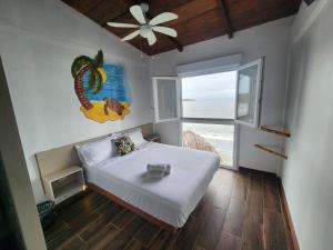 a bedroom with a white bed and a window at Basi Resort in Nombre de Dios
