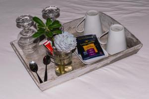 a tray with candles and flowers on a bed at Posada El Viejo Consulado in Colonia del Sacramento