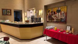 a restaurant with a counter and a table with a red cloth at Wilson Hotel in Salta
