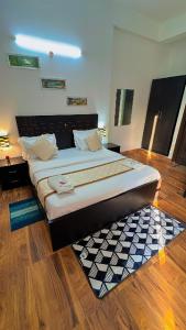 a large bed in a room with wooden floors at Vrindavan suites omex in Vrindāvan