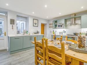 a kitchen with blue cabinets and a table with chairs at Carrie's Gate in Coniston