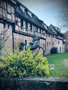 a statue of a woman in front of a building at Suite Richovilare - Sauna & Hammam in Riquewihr