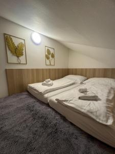 a bedroom with two beds with towels on them at Apartmán Klára in Terchová