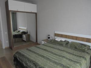 a bedroom with a large bed with a large mirror at apartament in Tbilisi City
