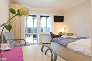 a bedroom with a bed and a table with a dining room at LC pokoje & apartamenty in Pobierowo