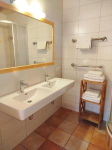 a bathroom with a sink and a mirror and towels at Ebner Casa in Heiligenblut +32 photos