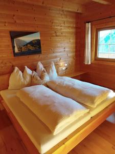 a bed in a log cabin with a window at Ebner Casa in Heiligenblut