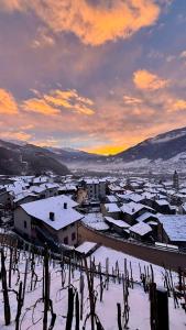a town with snow covered roofs and buildings with a sunset at Cà Marasciol in Villa di Tirano