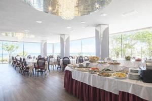 a banquet hall with tables and chairs with food on them at Hotel Regina Fronte Mare in Rimini