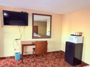a room with a television and a desk and a mirror at Aloha Inn McAllen Airport near Medical center Tx in McAllen