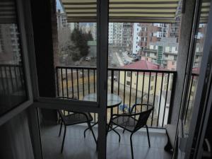 a balcony with a table and chairs and a view of a city at apartament in Tbilisi City