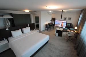 a bedroom with a large white bed and a desk at Blue Tree Premium Alphaville in Barueri