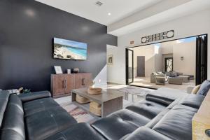 a living room with a couch and a tv on a wall at Azure Abode at Sand Hollow Resort in Hurricane