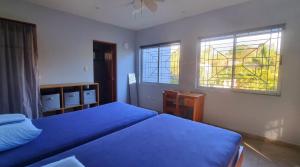 a bedroom with two beds and two windows at Casa Celeste in Playa Pelada