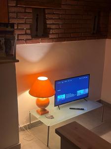 a lamp sitting on a table next to a television at La Gisina B&B in Gaglianico +5 photos