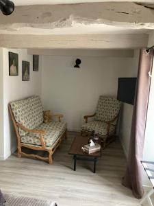 a living room with two chairs and a table at La suite de L'Eau qui dort in Pleslin-Trigavou