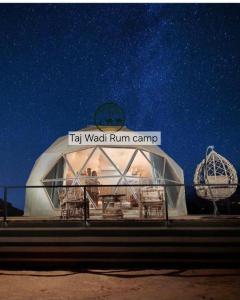 a large dome tent with people in it at night at Taj Wadi Rum camp in Wadi Rum