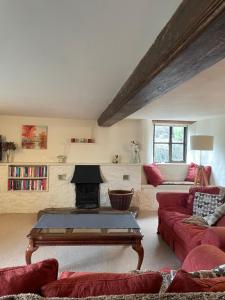a living room with a red couch and a fireplace at The Farmhouse in Teignmouth