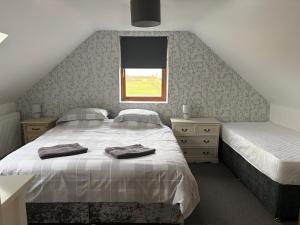 a bedroom with two beds and a window at The Gatehouse in Upwell