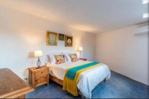 a bedroom with a bed and a table with a lamp at Business in-suite with office in San Miguel de Allende +13 photos