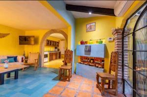 a living room with yellow walls and a table and chairs at Business in-suite with office in San Miguel de Allende