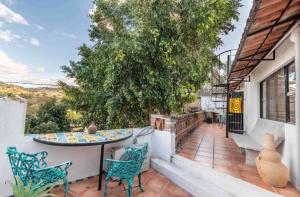 a patio with a table and chairs and a tree at Business in-suite with office in San Miguel de Allende