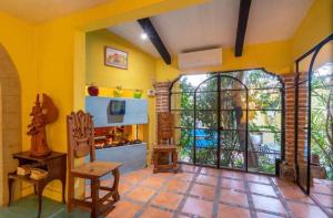 a living room with yellow walls and a large window at Business in-suite with office in San Miguel de Allende