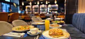 a table with plates of food and coffee on it at Garment District Suites in Athens