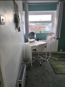 an office with a desk and a chair and a window at Sleepy Snug in Swansea