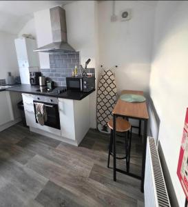 a small kitchen with a table and a stove at Sleepy Snug in Swansea