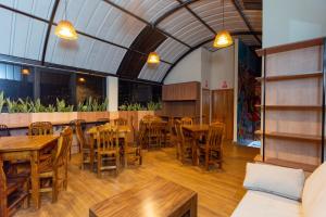 an empty restaurant with wooden tables and chairs at Samaran Wuasi in Puno