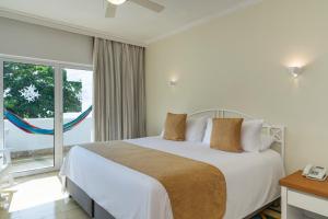 a bedroom with a bed and a large window at Hotel Las Americas Casa de Playa in Cartagena de Indias