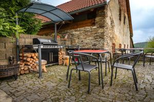 a group of chairs and tables in front of a grill at U Hudečků in Zadov +19 photos