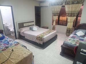 a hotel room with two beds and a suitcase at Hotel Gallineral in San Martín +13 photos