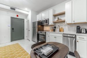 a kitchen with white cabinets and a wooden table at Park Hotel Studio Suite 307 in Chattanooga +23 photos
