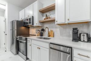 a kitchen with white cabinets and stainless steel appliances at Park Hotel Studio Suite 307 in Chattanooga