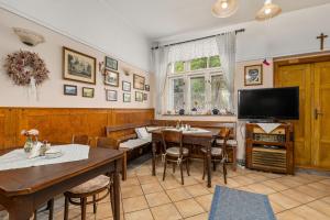 a dining room with a table and a tv at U Hudečků in Zadov