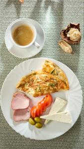 a white plate of food and a cup of coffee at Hotel VULTURUL Pitesti in Piteşti